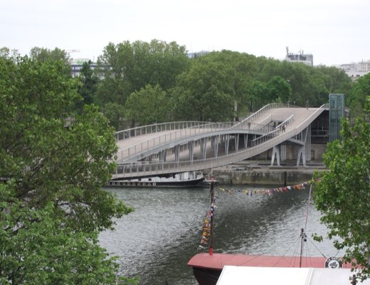 Moderní zakřivená lávka Simone-de-Beauvoir mezi Národní knihovnou a parkem Bercy