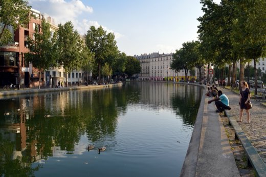 Canal Saint-Martin z nábřeží Quai de Valmy, lemovaný stromy a pařížskými domy