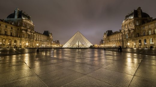 Osvětlená pyramida před Louvrem v noci na nádvoří Cour Napoléon